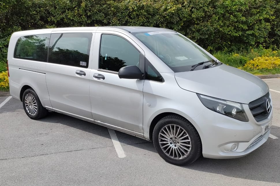 White minibus parked at the curb